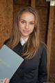 A woman in a business suit holding a book.