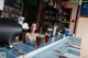 A woman sitting at a counter with a glass of beer.