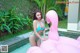 A woman in a blue bikini standing next to a pink flamingo.