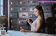 A woman sitting at a table in front of a bunch of drawers.