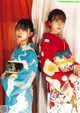 Two women in kimonos standing next to each other. 