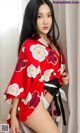 A woman in a red and white kimono posing for a picture.